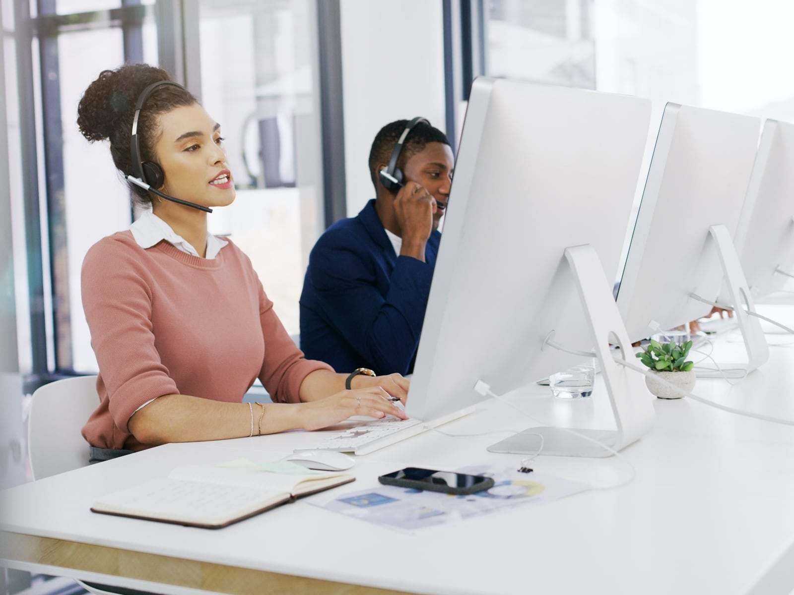 Woman sitting at office desk answering customer support calls