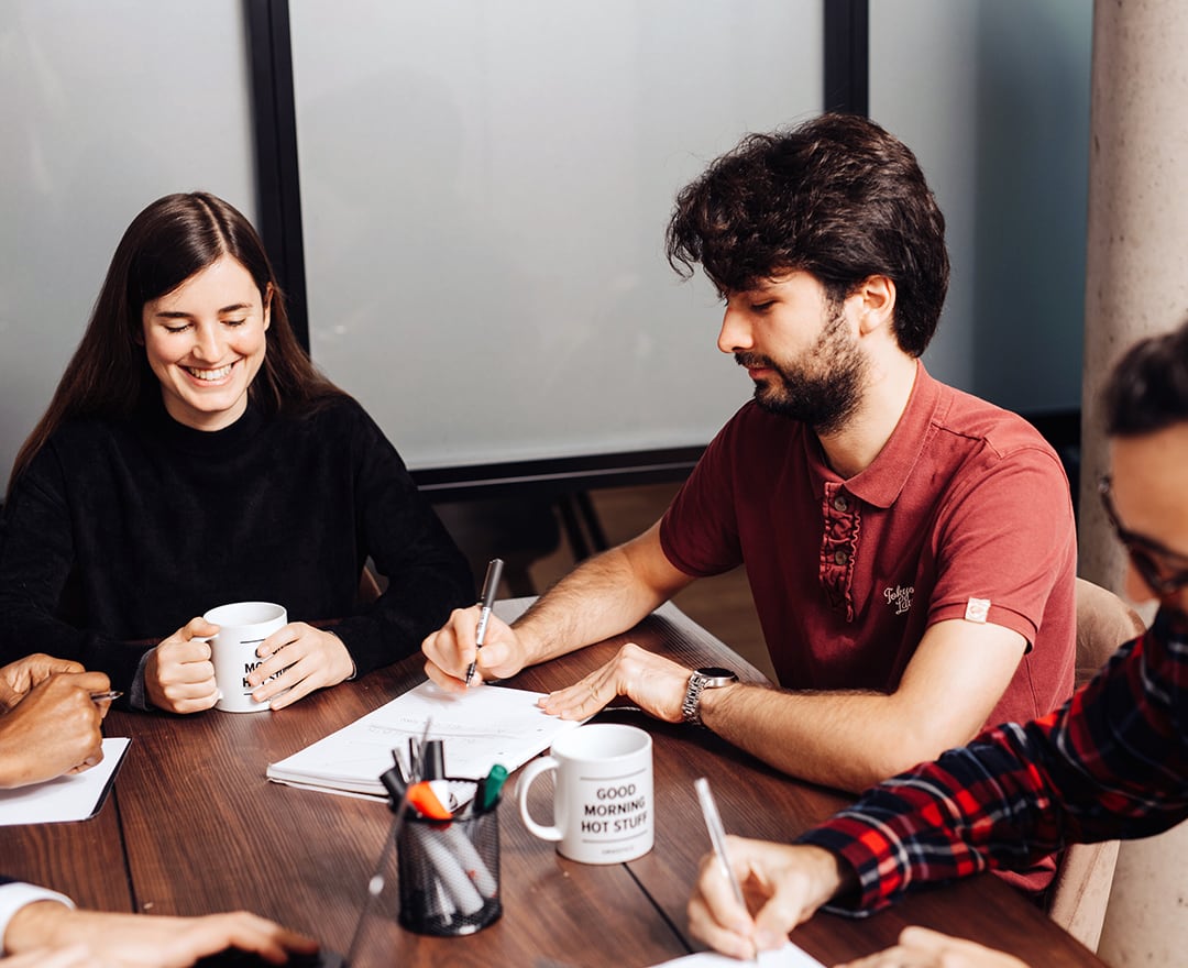 Colleagues laughing in meeting room