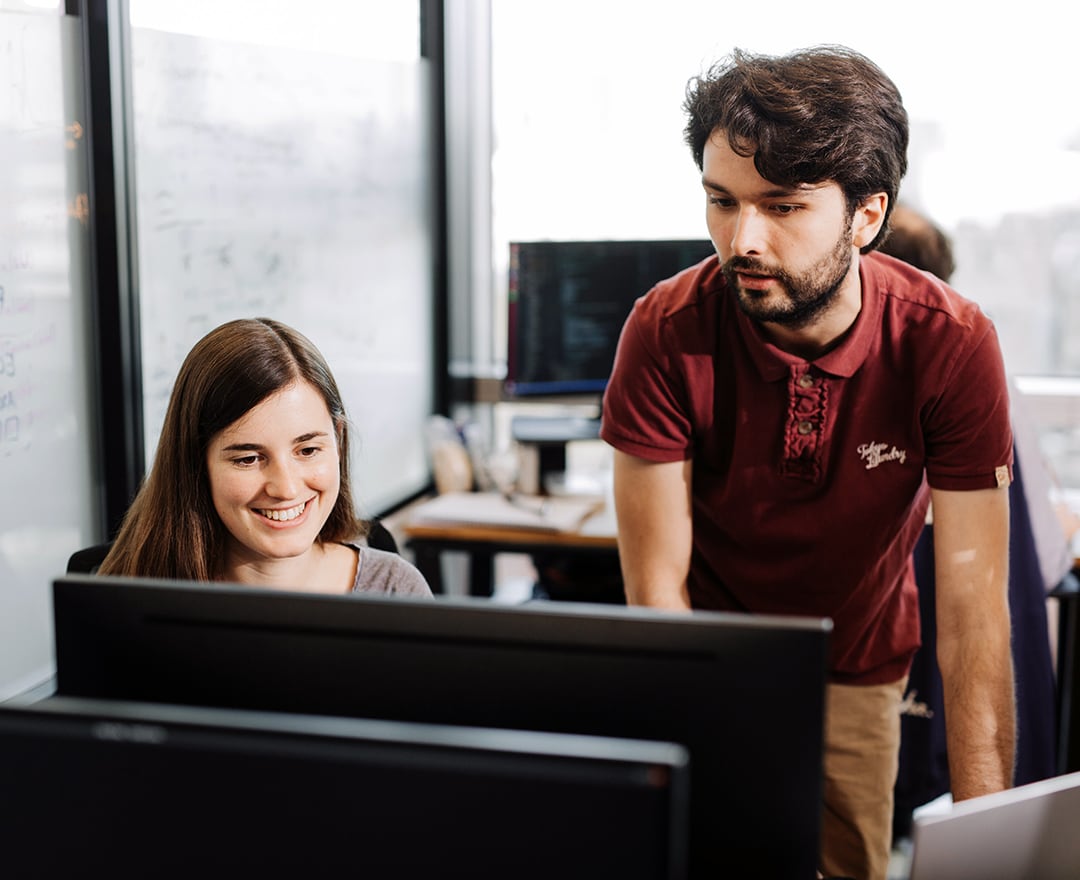 Colleagues looking at screen in office