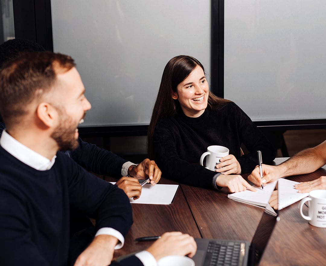 Colleagues laughing in meeting room