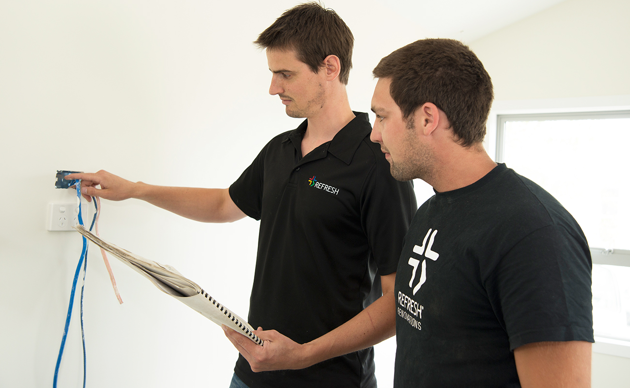 Professionals assessing a new electrical outlet.