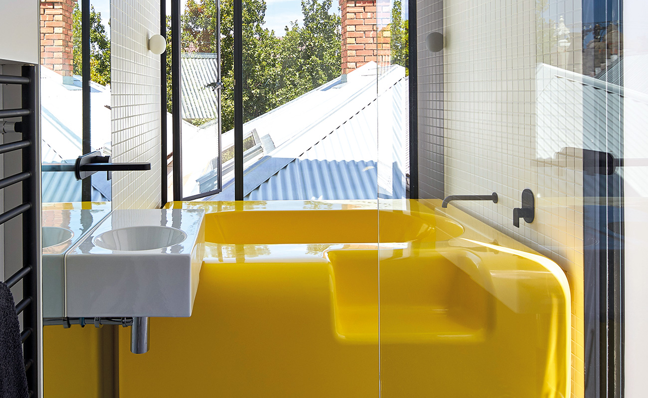 Желтая ванна в ванной со стеклянной стеной