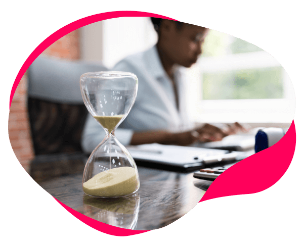 Image of an hourglass with a lady working in the background
