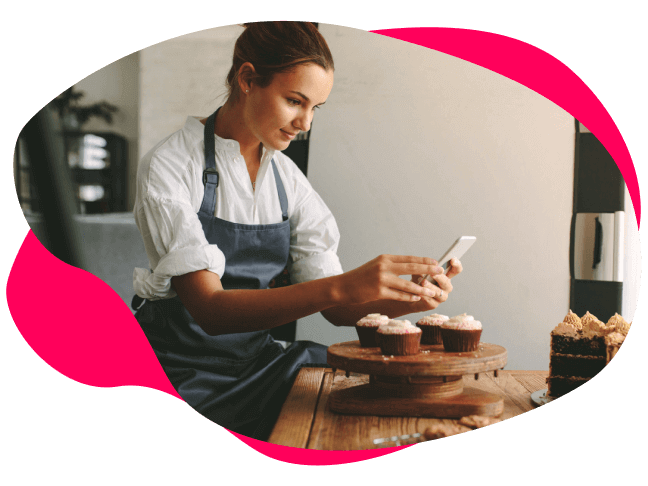 Image of a baker taking a photo of cakes