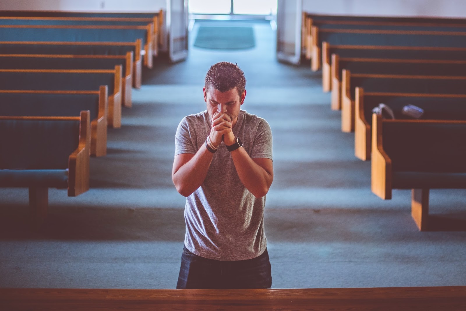 a man on his knees in a church praying