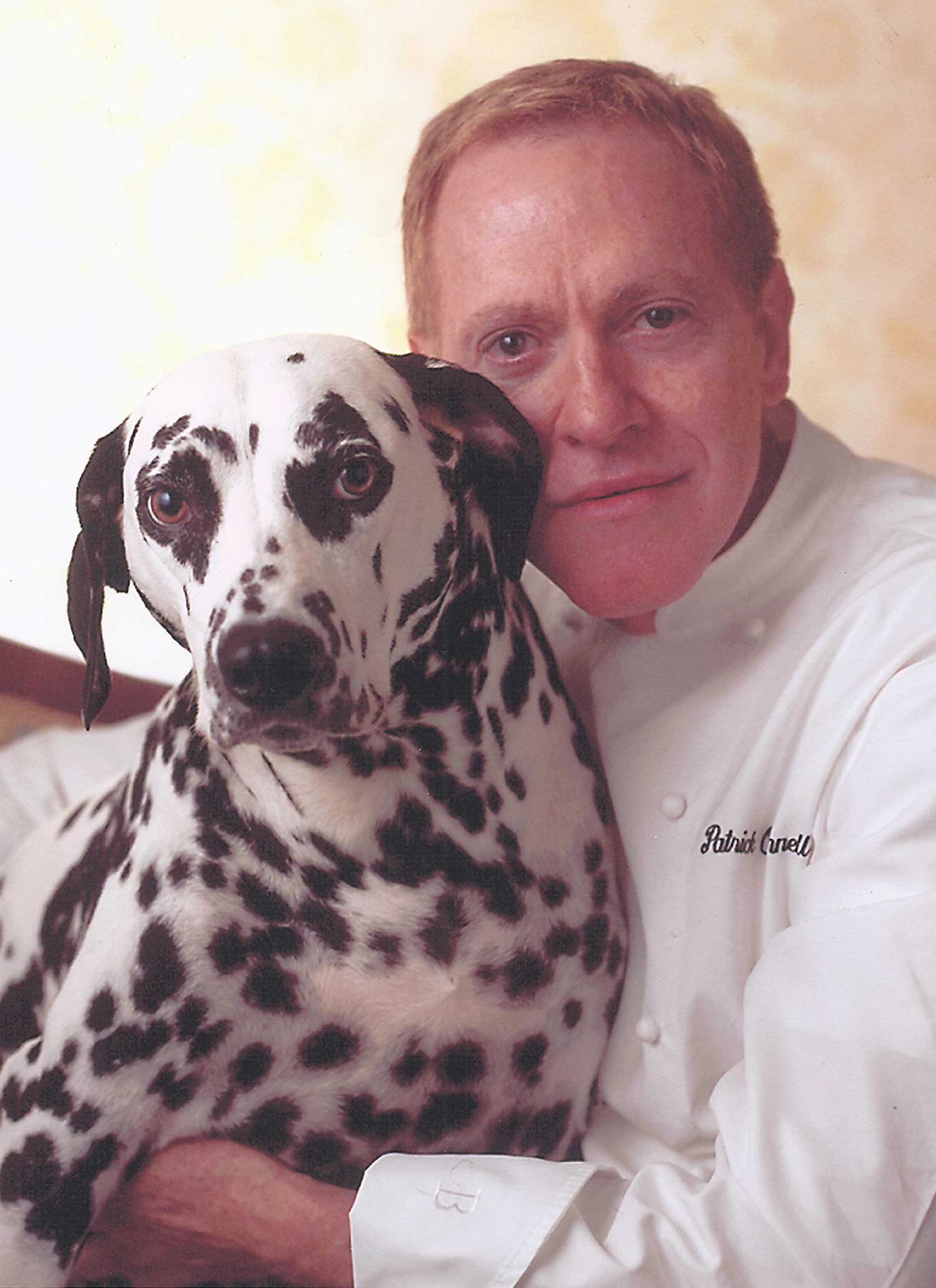 Chef Patrick O'Connell hugging a dalmation.