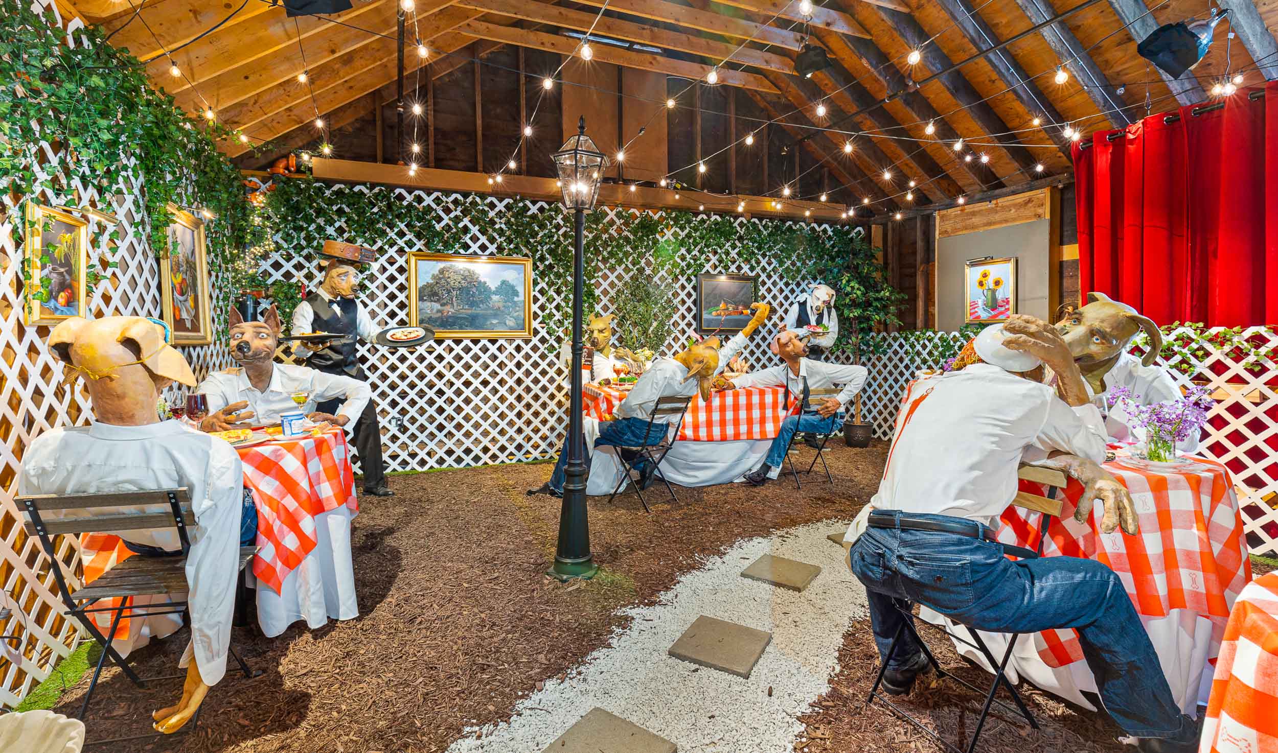 An anthropomorphic dog looks at you over the back of a dinner chair. He is wearing a red fez, has bushy eyebrows, and is smoking a cigar. A raucous dog dinner goes on at the table behind him.