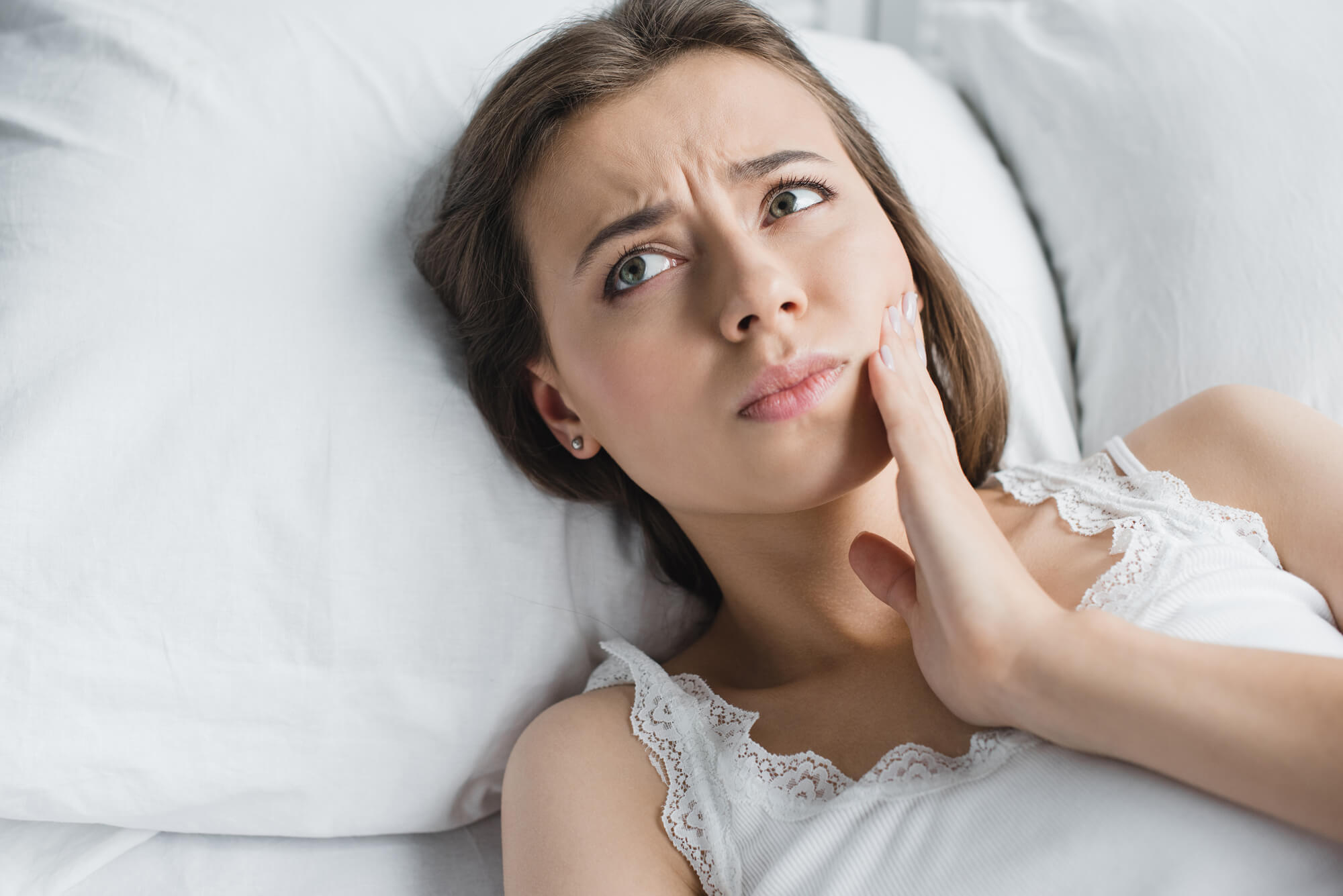 Woman lying in bed in pain after a Tooth Removal 76210 Woman lying in bed in pain after a Tooth Removal 76210