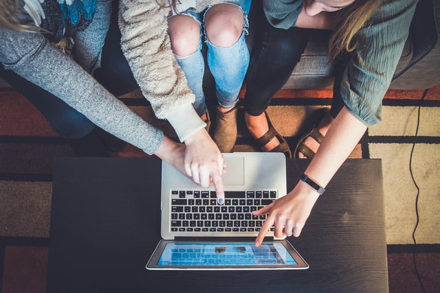 Three people looking at laptop.