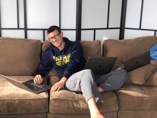 Image of AJ with 3 laptops working on Conscious Insights