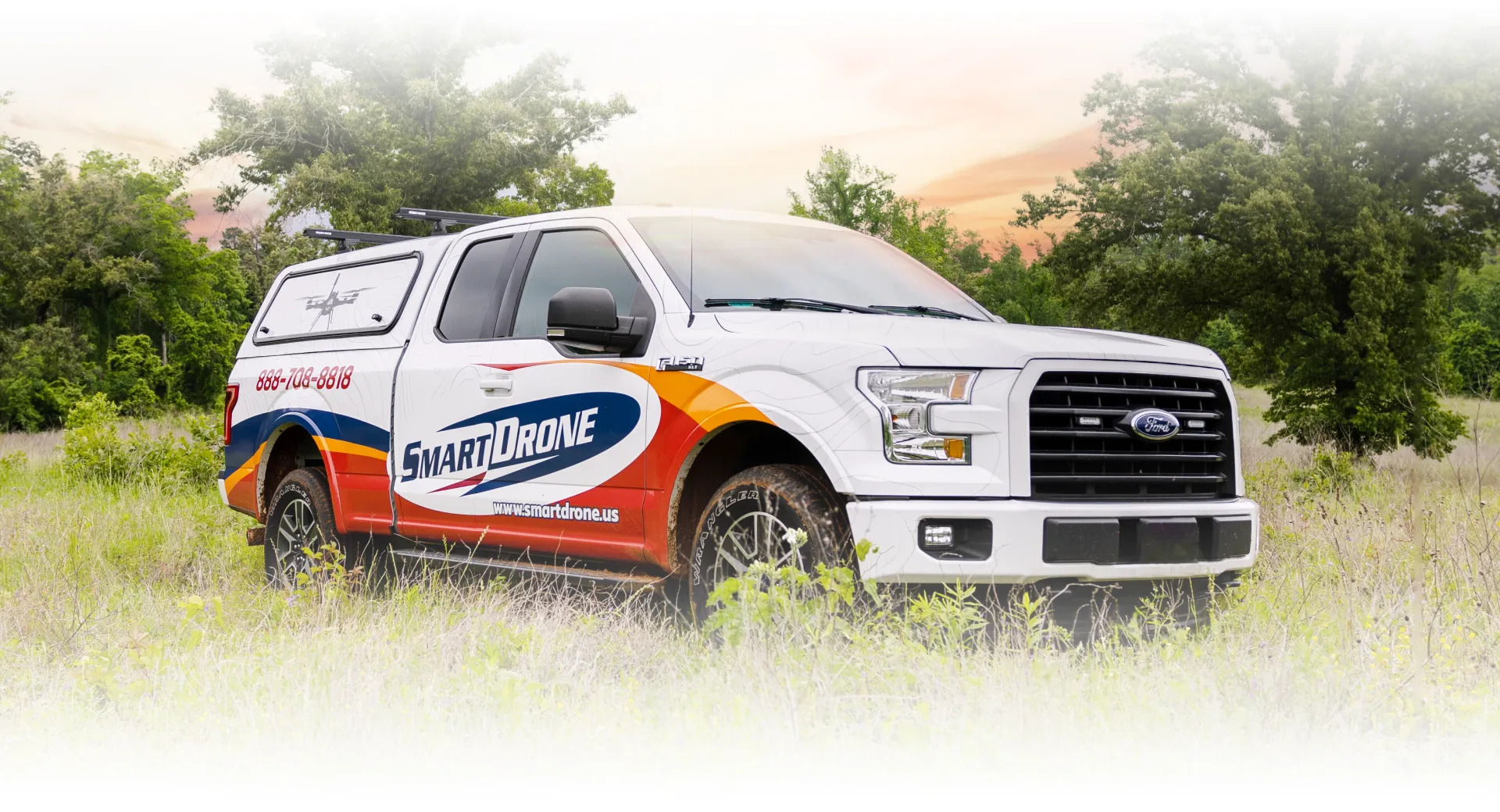 A SmartDrone Professional Services truck at a job site during sunset.