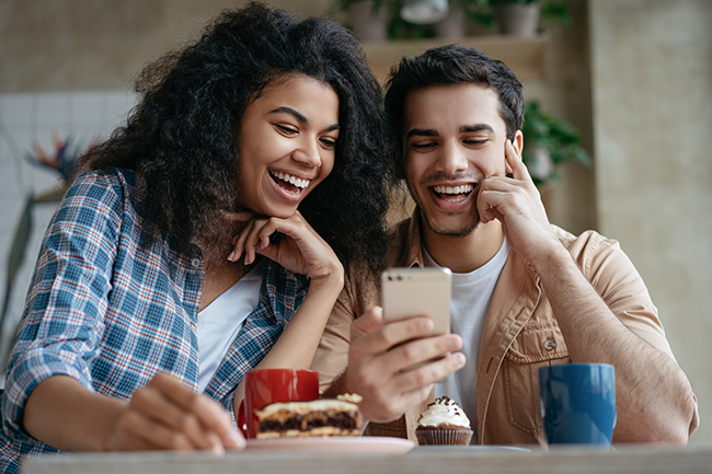 couple laughing looking at phone