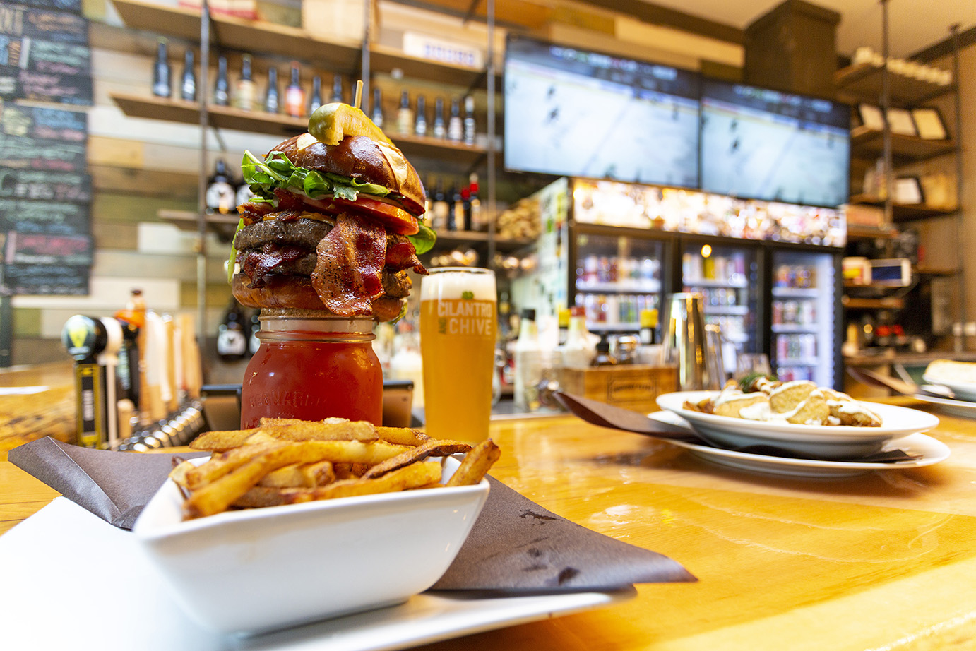 Burger that eats like a meal sitting on top of a ceasar with a side of fries