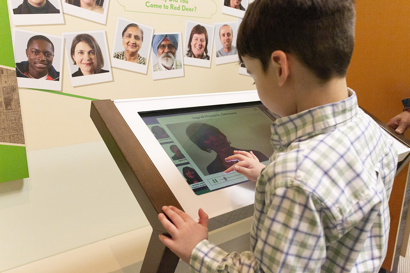 Red Deer Museum & Art Gallery with a young child using a computer display to learn about family history