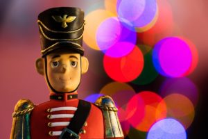 A nutcracker soldier in front of Christmas Lights