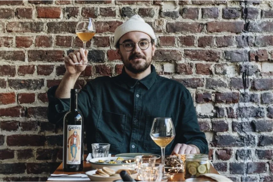 L'influenceur Whoogy's levant son verre de vin lors d'un repas