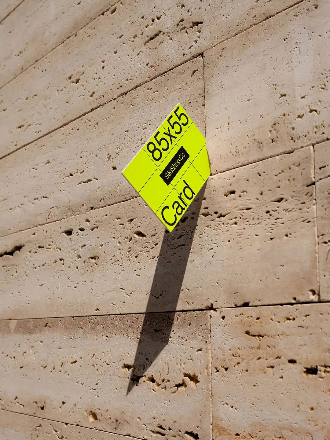 Business card mockup with a bright yellow background and '85x55 mm' dimensions, 'SedShop.Co' branding, against a textured stone wall.