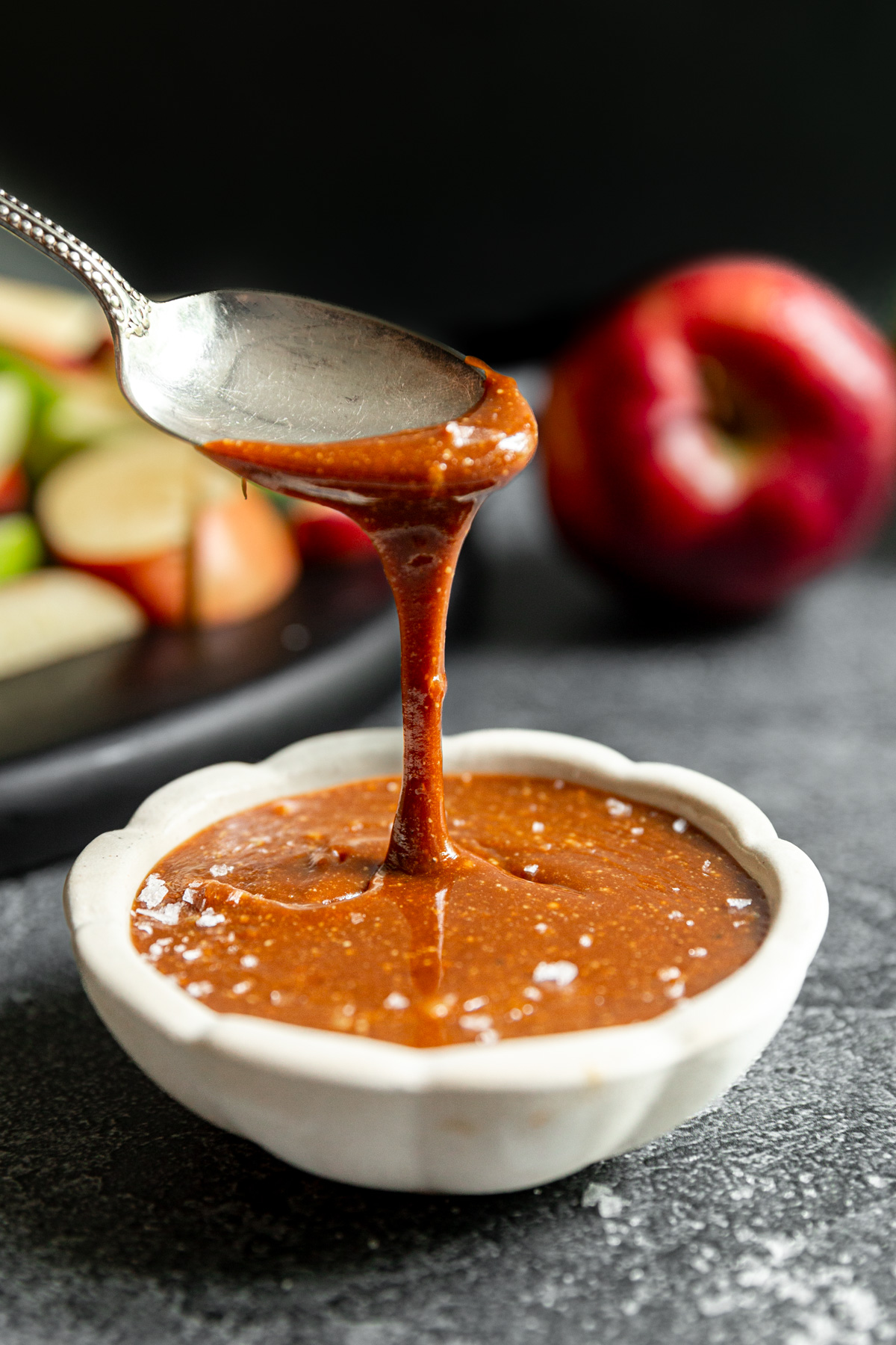 A spoon scooping a drizzle of vegan caramel.