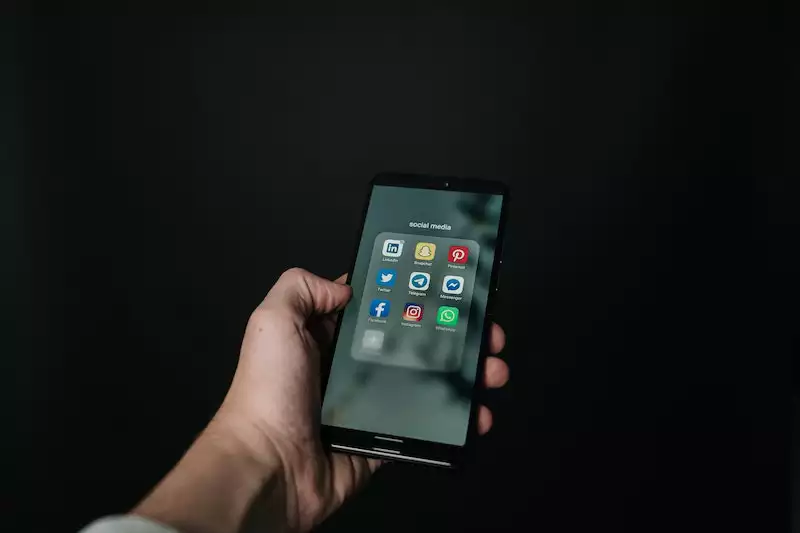 A man holding a mobile phone on the hand and using social media app