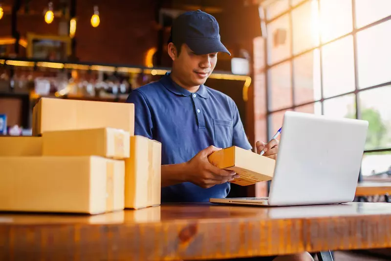 A man is seller something in the brown box