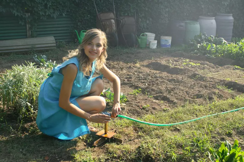 A lady joining  pipe on the  garden