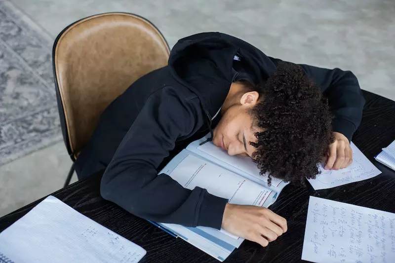 A guy fall sleep while studying 