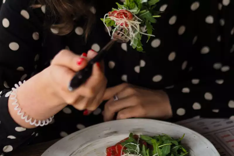 A lady eating salad 