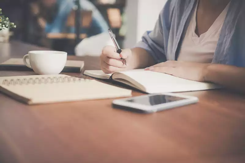 A lady writing on the book 