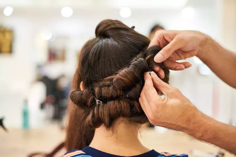 A man stylish making hair of girl