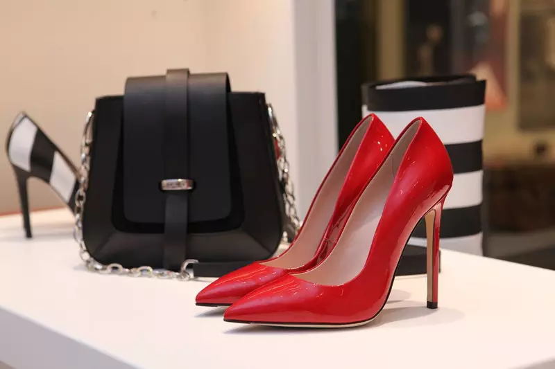 A hand bag and two heels on the table