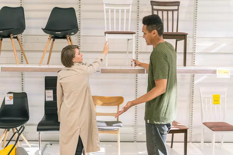A man selling chair to lady