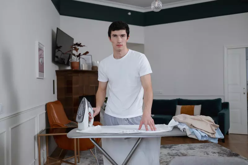 A man ironing a clothes