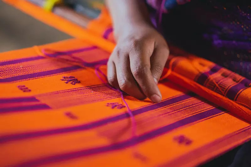 A lady making hand loom