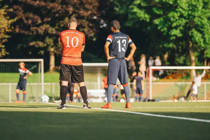 2 man standing on foot ground 