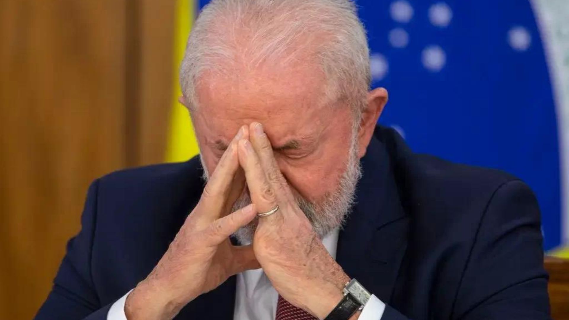 Lula apoiando o rosto entre as mãos