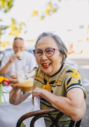 A woman smiling holding a drink