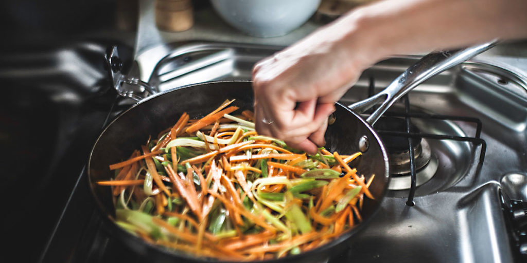 stir frying fresh vegetables in frying pan