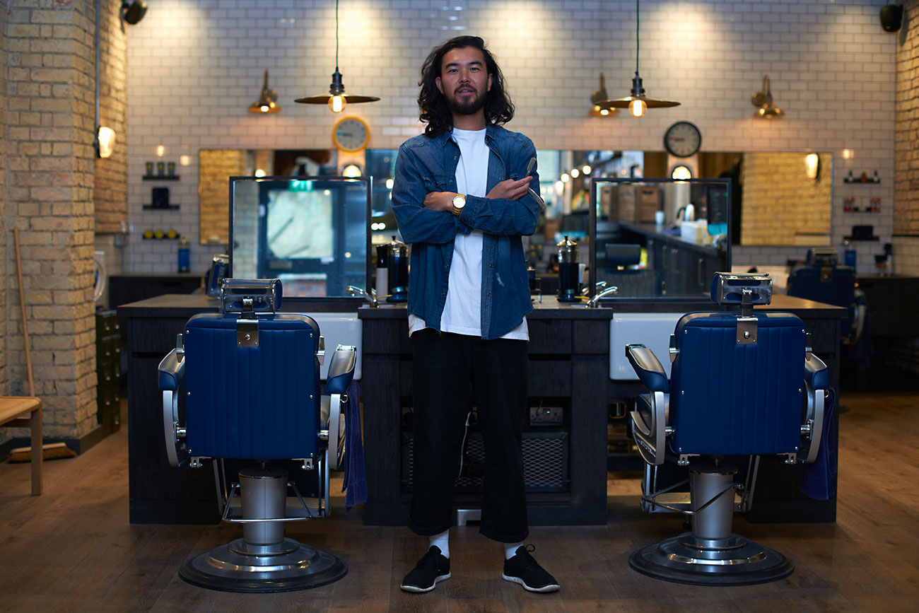 Portrait of barber with arms folded in retro style barber shop