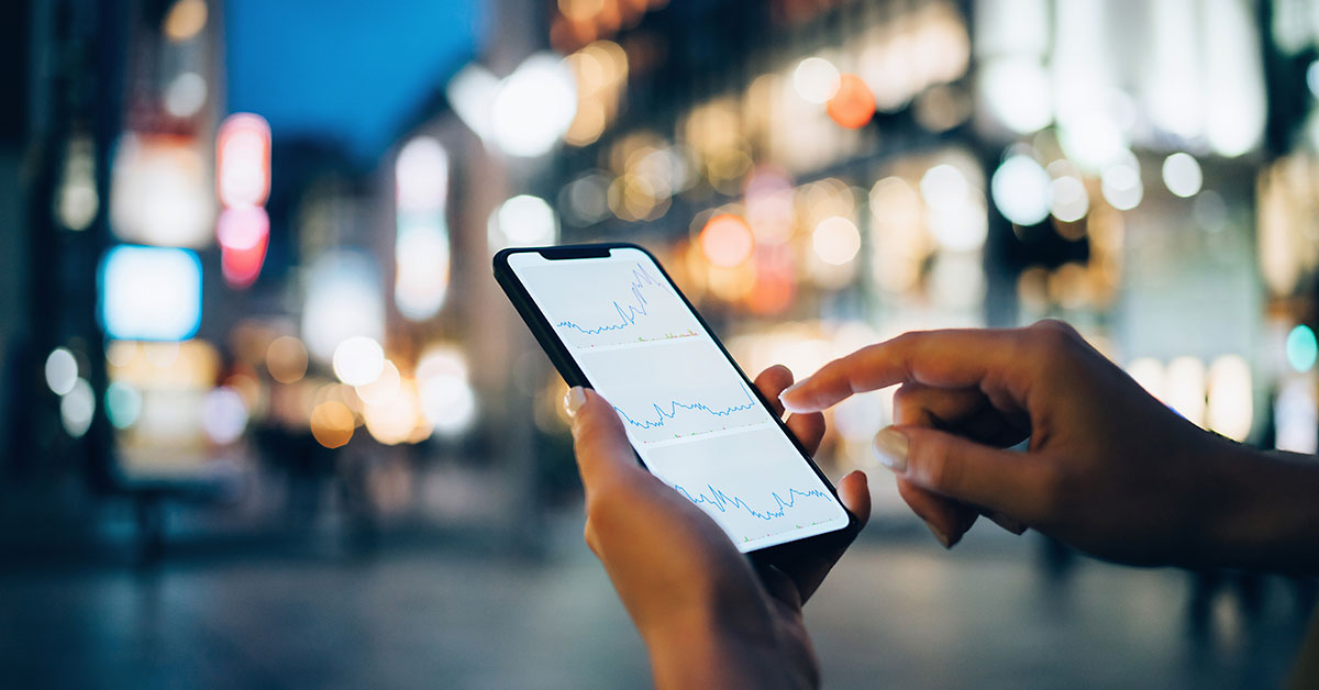 Businesswoman reading financial trading data on smartphone