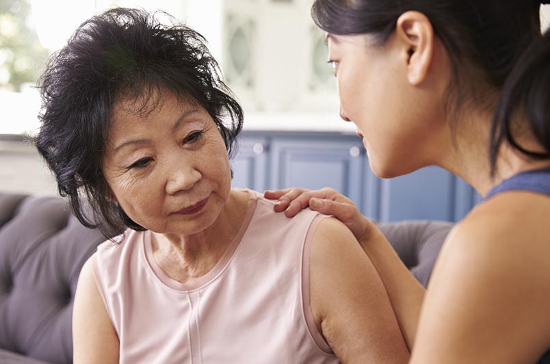 A woman with her hand on an older woman's shoulder