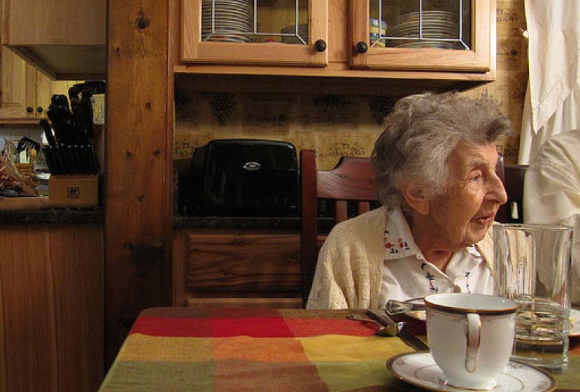 A woman sitting at a table and looking out a window