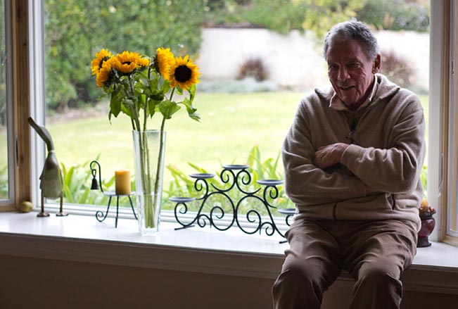 A man sits on a window sill