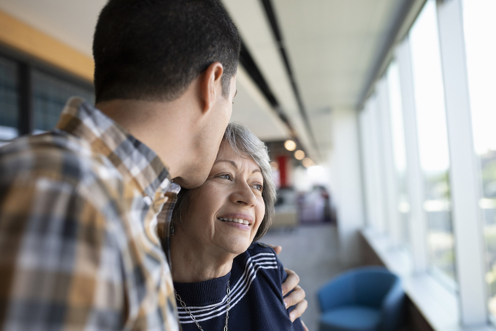 a young person is gently holding an older person