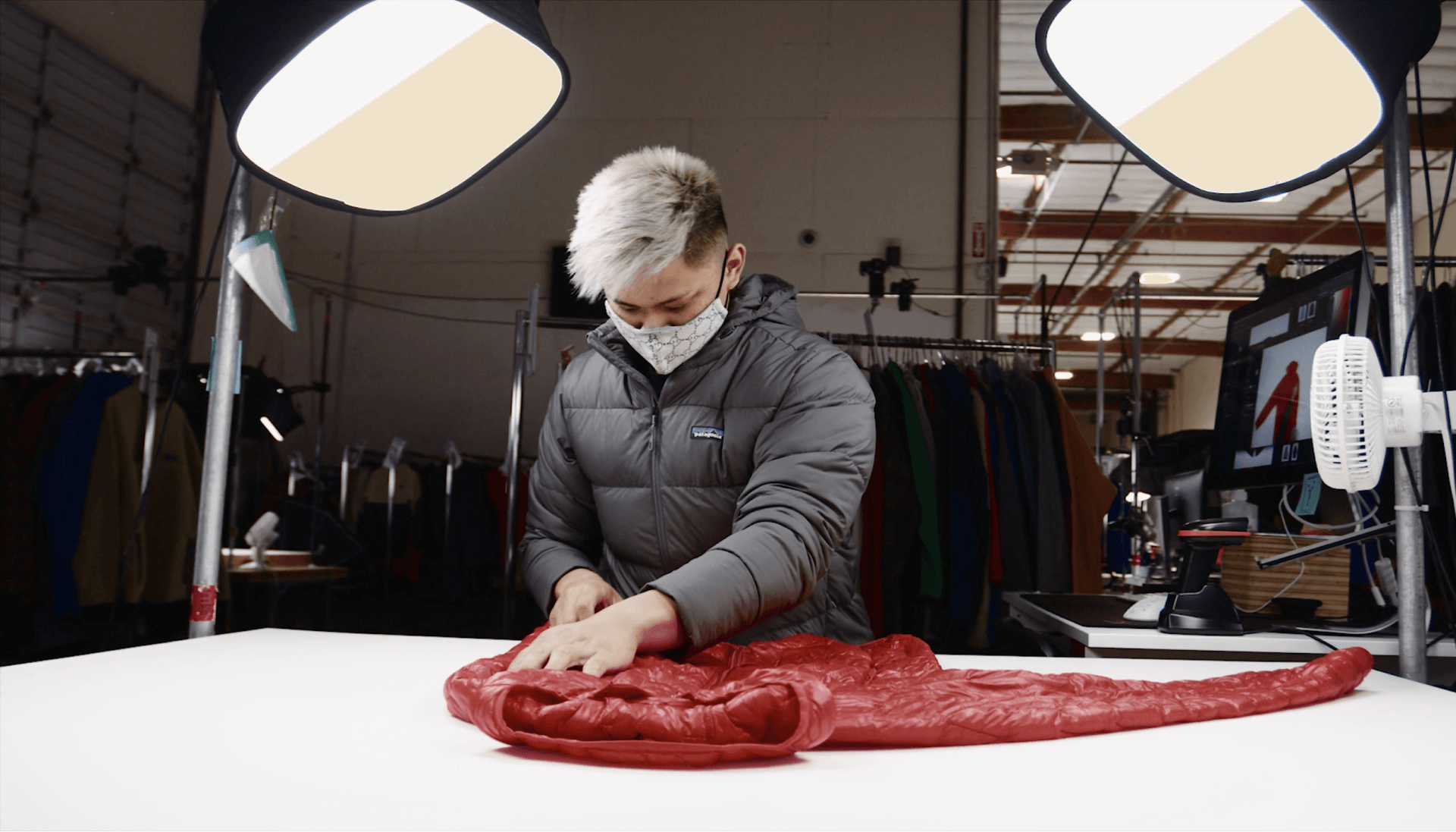 Sustainable trend sewing and reparing red jacket inside warehouse or factory