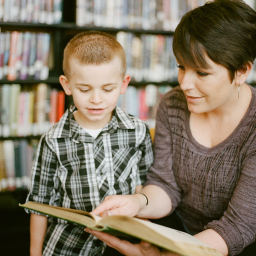 professora com aluno em concurso de leitura