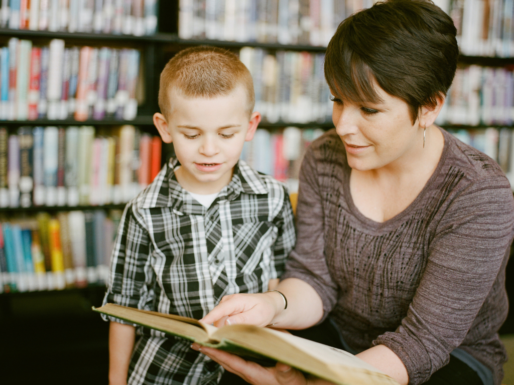 professora com aluno em concurso de leitura