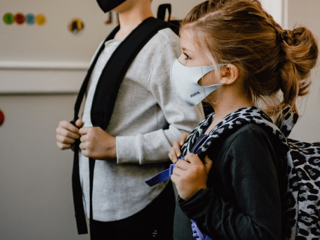 crianças com máscara indo para escola
