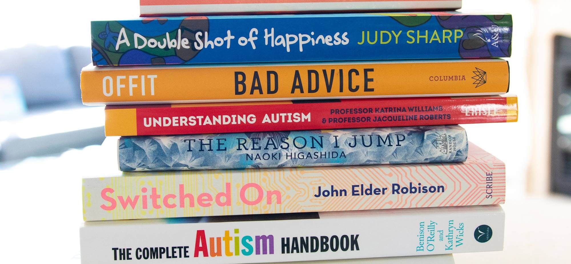 Stack of books about autism with spines showing