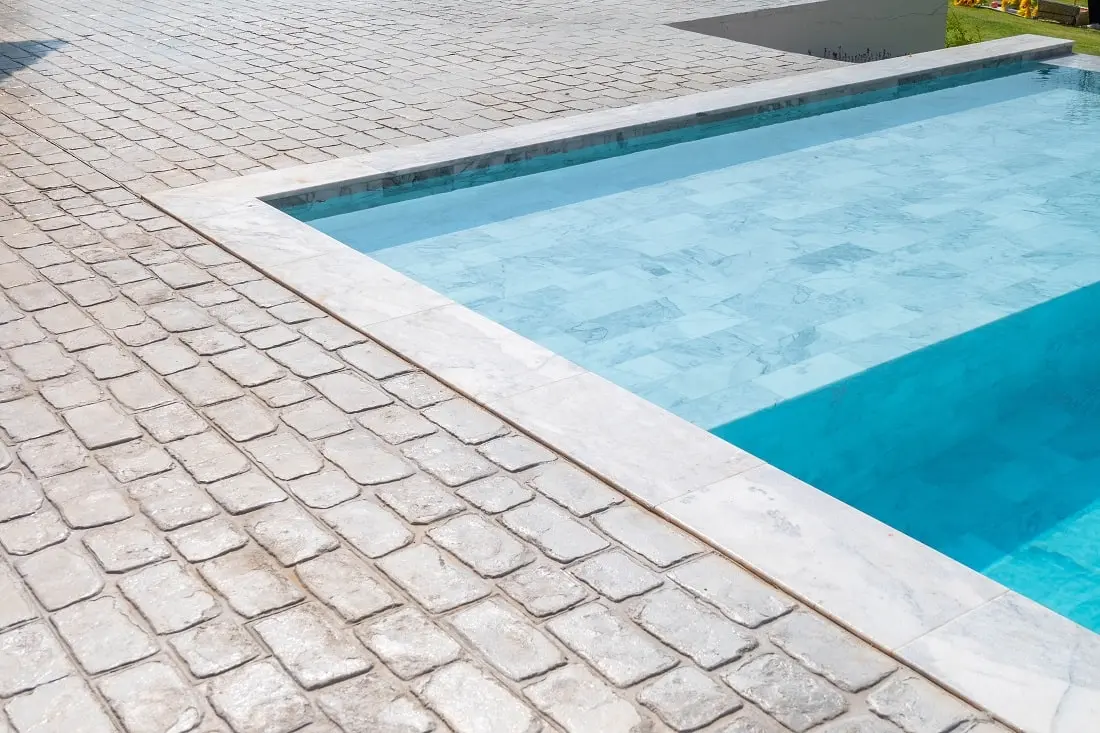 Travertine vs Pavers: Which Is Better for Your Pool Deck?