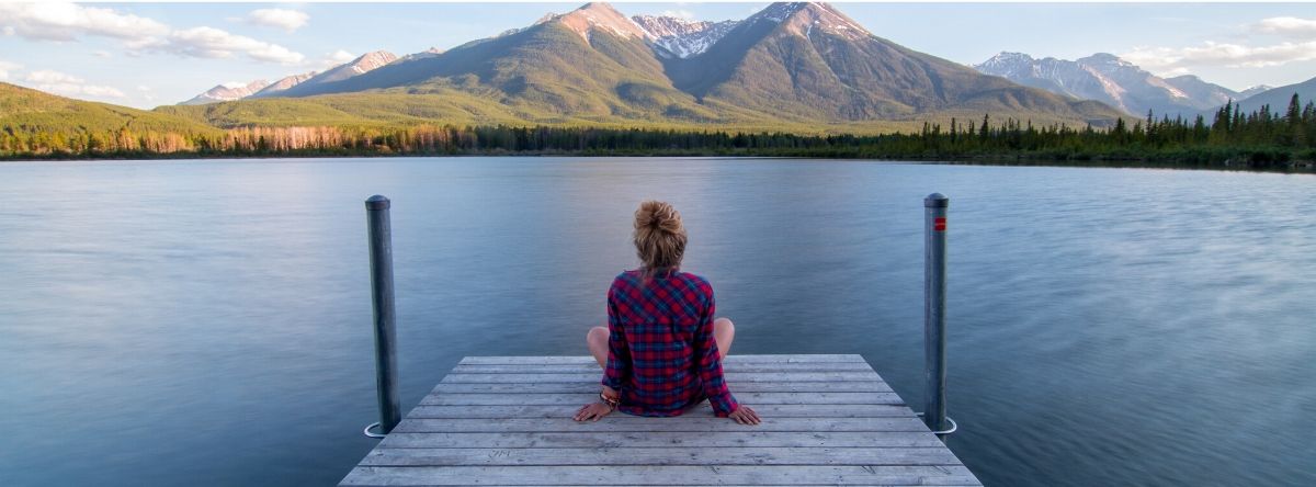 Woman sitting by lake 